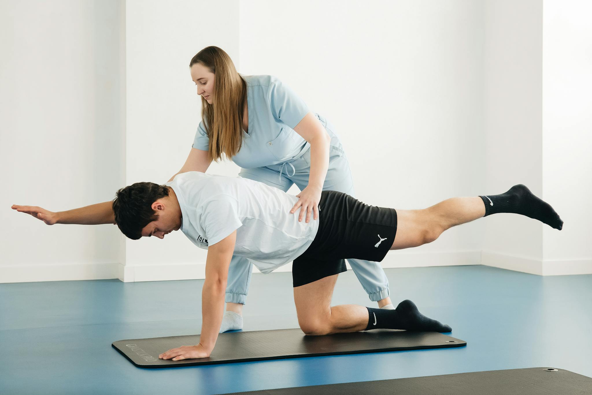 A physiotherapist assists a patient with exercises in a modern clinic setting.