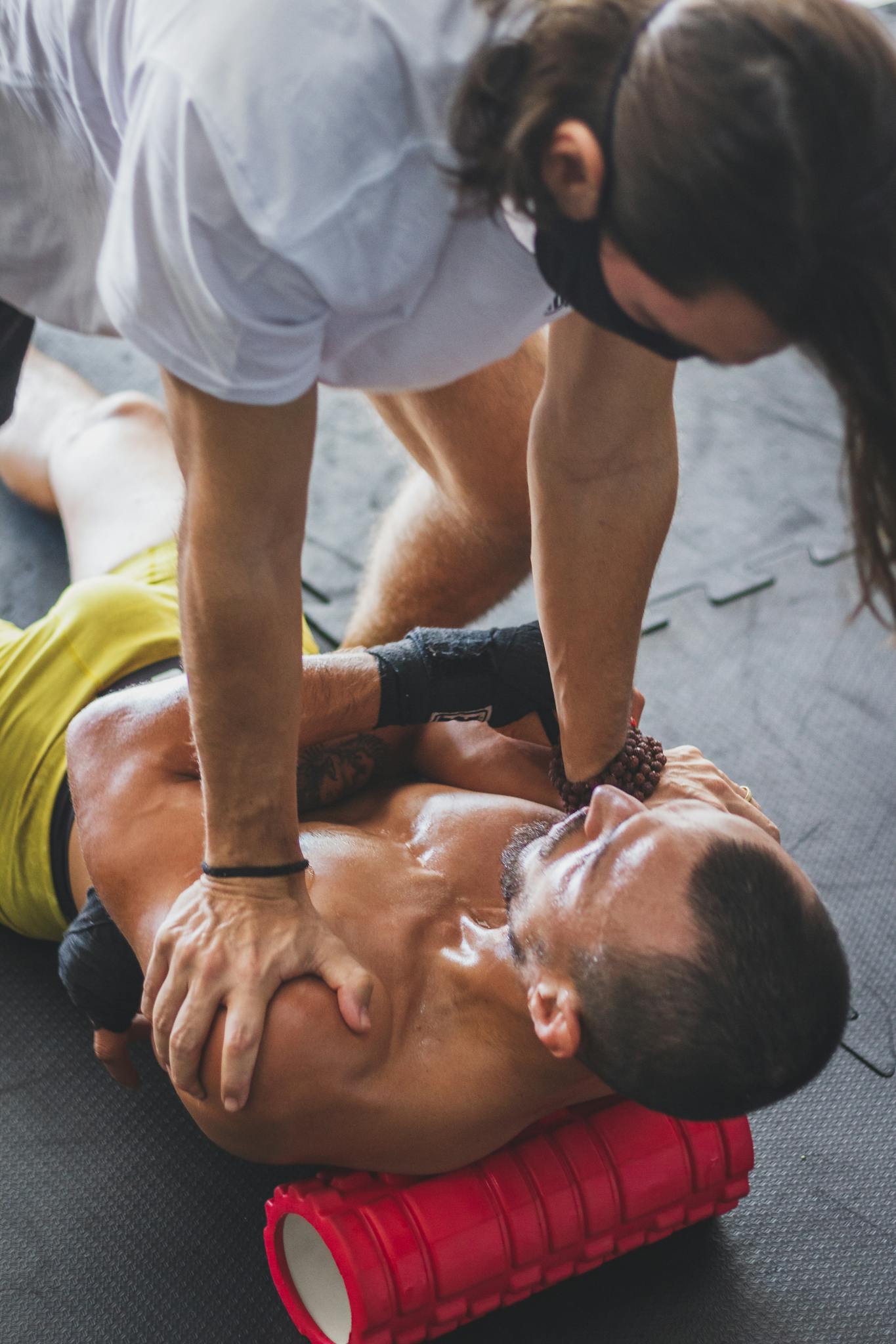 Athlete receiving therapeutic massage using foam roller for muscle relaxation and recovery