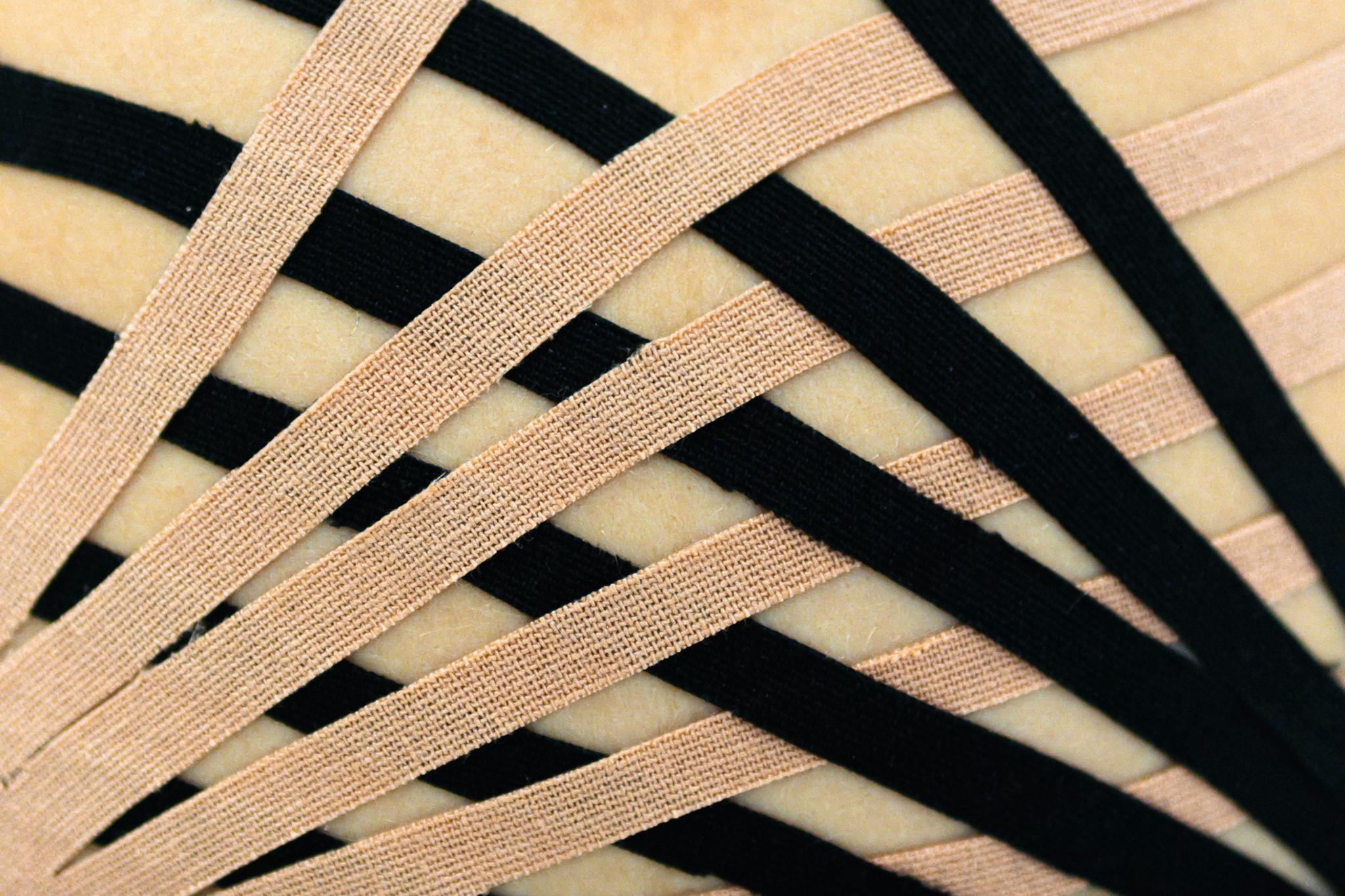 Detailed view of elastic therapeutic kinesio tape applied to skin, showcasing intricate pattern.