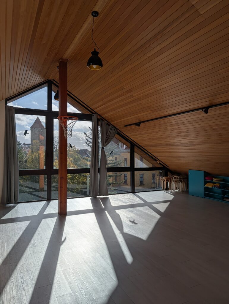 Gruppenraum mit Holzdecke und großer Fensterfront